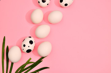 White easter hand drawn eggs with green myrtle leaves pattern on trend pink pastel color background. Spring and Easter holiday concept with copy space.