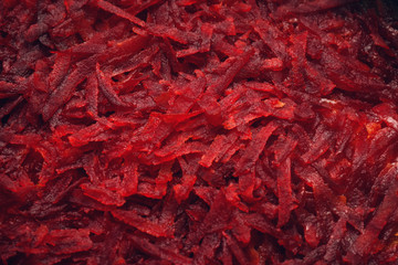 Closeup macro photo of thickly grated or shredded fresh beetroot (beet-root) to cook or use as an...