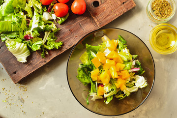 Healthy vegan food. Vegetable salad dressing, tomatoes, bell peppers, avocado. Close-up. Top view. Glass plate. Step by step cooking. Vegetarianism and veganism.
