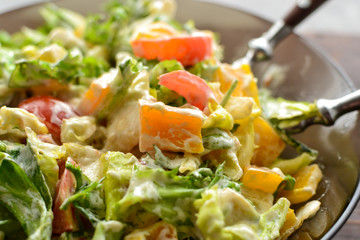 Healthy vegan food. Useful vegetable salad dressing, tomatoes, bell peppers, avocado. Close-up. Vegetarianism and veganism.