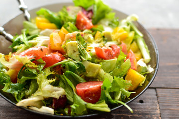 Healthy vegan food. Useful vegetable salad dressing, tomatoes, bell peppers, avocado. Close-up. Vegetarianism and veganism.