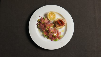 Tartar of fish with pumpkin seeds, with fish paste with sun-dried tomato and lemon.       