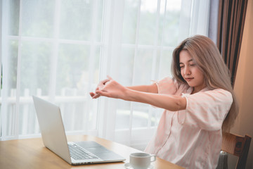 Lazy bored asian woman using laptop in the morning.