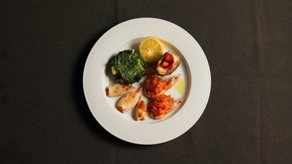 Fried squid, shrimp with tomato sauce, potatoes with spinach, brancin fish with fried carrots.