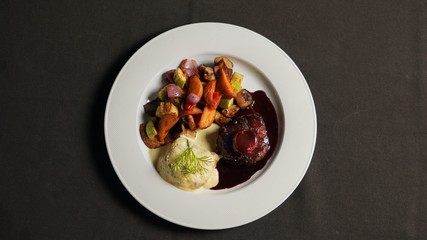 Beef steak with soy sauce, baked potatoes and vegetables.  