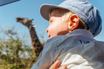 Baby boy enjoying giraffe in Kruger National Park, South Africa
