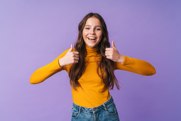 Image of young beautiful woman smiling and gesturing thumbs up