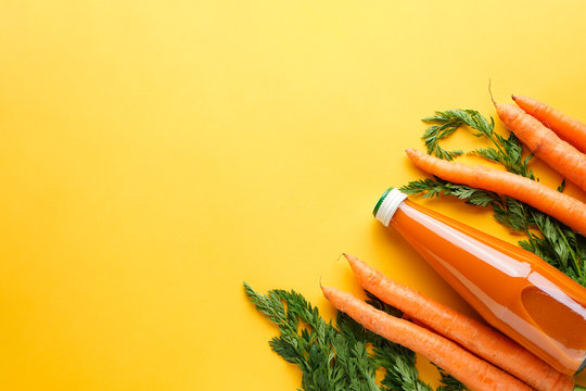Flat lay composition with ?arrot juice in a bottle with fresh carrots on a yellow background.