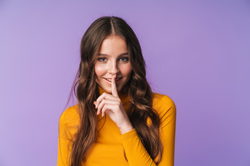 Image of young beautiful woman smiling and doing shh gesture