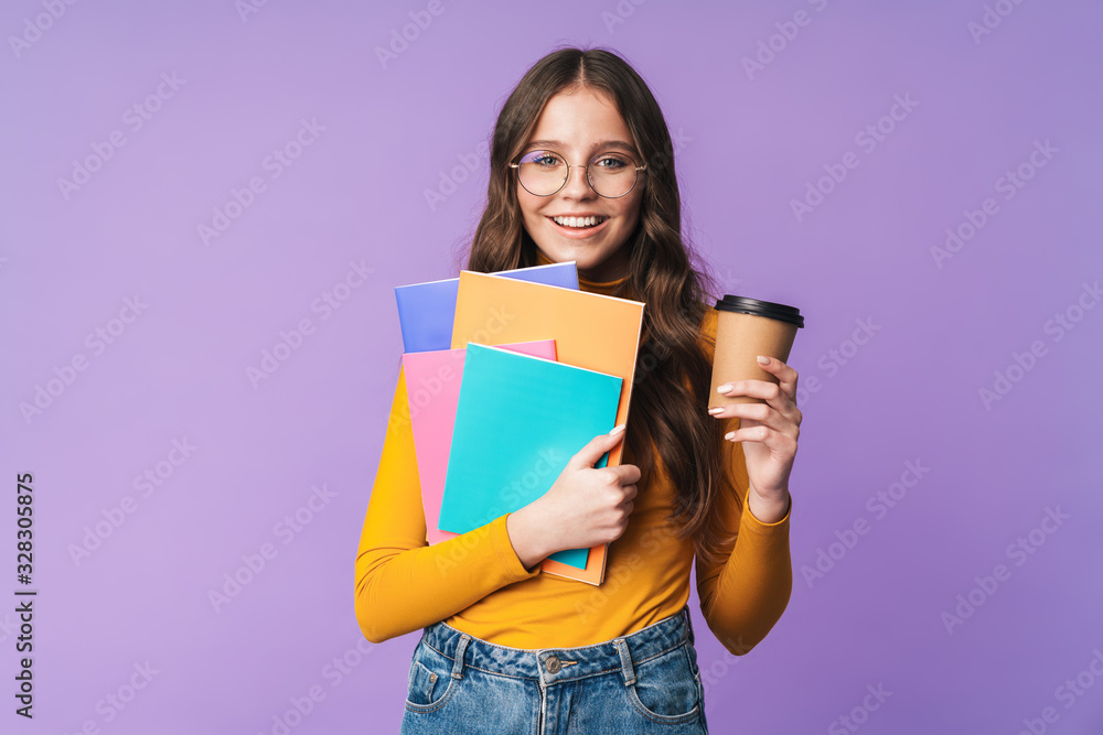 Wall mural image of young student girl holding exercise books and coffee cup