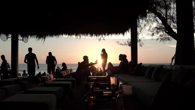 Friends having fun on the beach party during the sunset time
