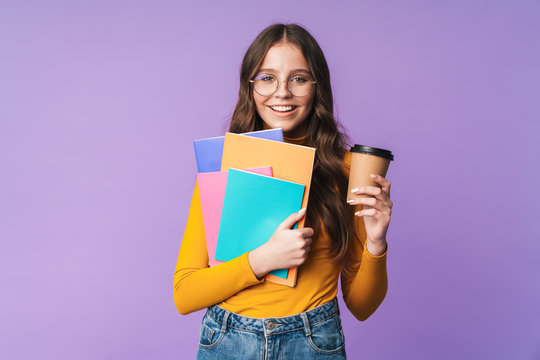 Image of young student girl holding exercise books and coffee cup