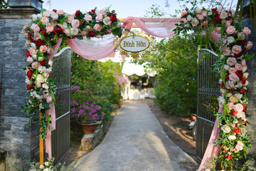 BEN TRE PROVINCE, VIETNAM - MARCH, 2020: The engagement gate in western Vietnam is decorated with many pink flowers and chiffon fabric, traditional wedding