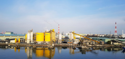 Japan - February 20, 2019: Many factory of industrial type are located near the river with clear...