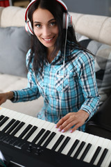 Girl with headphone record composition on piano. Music composer working in cozy recording studio. Woman uses modern devices to play electronic piano. Hobby brings happiness at free time