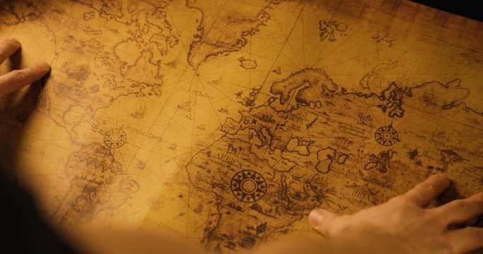 hands opens rolled old world map