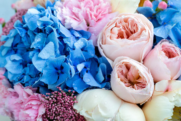 Selective focus. Bouquet of gentle peony flowers, blue hortensia flower and pink carnations with...