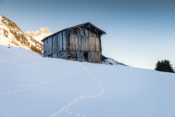 An old wooden barn in the snowy Alps in Austria.