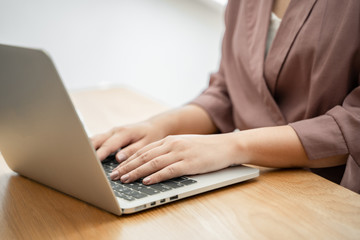 Close up of woman using laptop computer indoor.