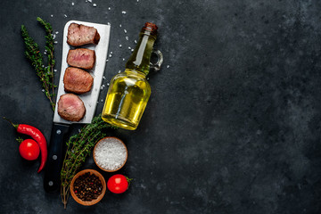  Grilled beef steak over meat knife with spices. View from above. on a stone background. with copy space for your text