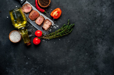  Grilled beef steak over meat knife with spices. View from above. on a stone background. with copy space for your text
