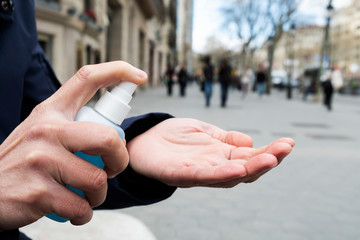 man disinfecting his hands with hand sanitizer