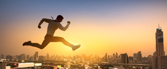 Young businessman jumping high, Work, job, or successful business concept. Cityscape background.