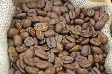 Coffee beans roasted to golden and brown are on the counter in the store