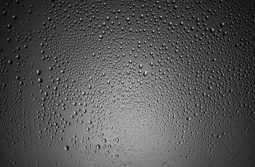 texture of large and small drops of water on a matte black and white surface