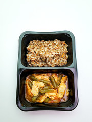 Healthy food in plastic boxes, buckwheat and chicken with string beans on an isolated background.