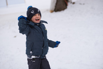 Fototapeta na wymiar Young boy with snowball playing outdoor
