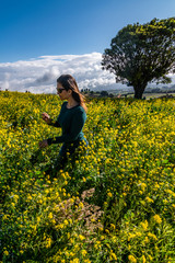 woman with sunglasses in a yellow flowers field