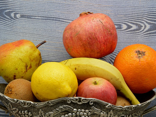 fresh fruits in a basket on wooden background