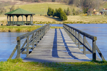 The wooden bridge has a beautiful view of the ancestry and the frozen lake
