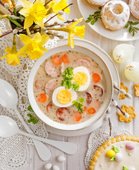 The sour soup (Żurek) polish Easter soup with the addition of sausage, hard boiled egg and vegetables in a ceramic bowl, top view.  Traditional Easter food in Poland