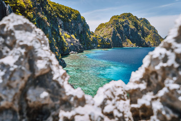 El Nido, Palawan, Philippines. Matinloc island and tapiutan strait framed by limestone sharp rocks in foreground. Bacuit Archipelago
