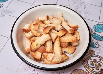 Crackers of wheat bread and rye bread lie on a plate on the table on the kitchen