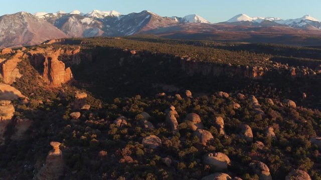 Drone Aerial Reveal Shot of Desert Canyon & La Sal Mountains Near Moab, Utah U.S.A. Above Desert in Summertime at Sunset