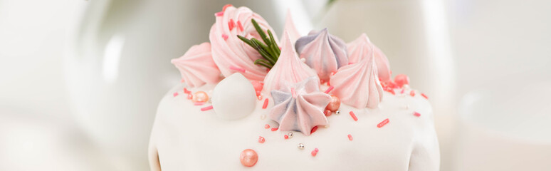 Close up view of delicious Easter cake with white glaze and meringue, panoramic shot