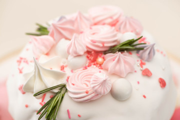 close up view of tasty Easter cake with rosemary and meringue on glaze