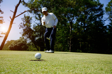Blurred golfer playing golf in the evening golf course, on sun set evening time.