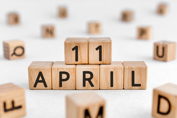 April 11 - from wooden blocks with letters, important date concept, white background random letters...