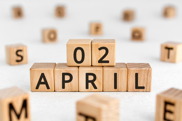 April 2 - from wooden blocks with letters, important date concept, white background random letters around