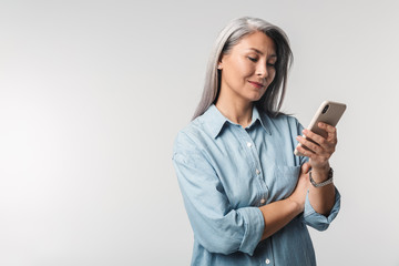 Image of adult mature woman with long white hair holding cellphone