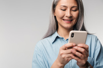 Image of adult mature woman with long white hair holding cellphone