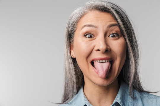 Image of adult mature woman with long white hair sticking out her tongue