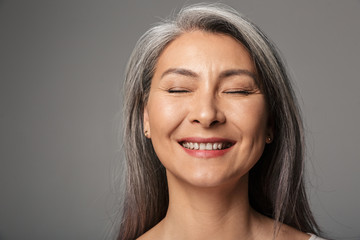 Image of adult woman wearing striped shirt smiling with eyes closed