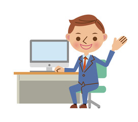 デスクでノートパソコンを使うビジネスマン（振り返って説明）