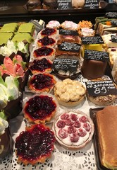 Delicious cakes with cream and berries in the shop