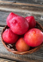 Fresh red plums on a wooden table